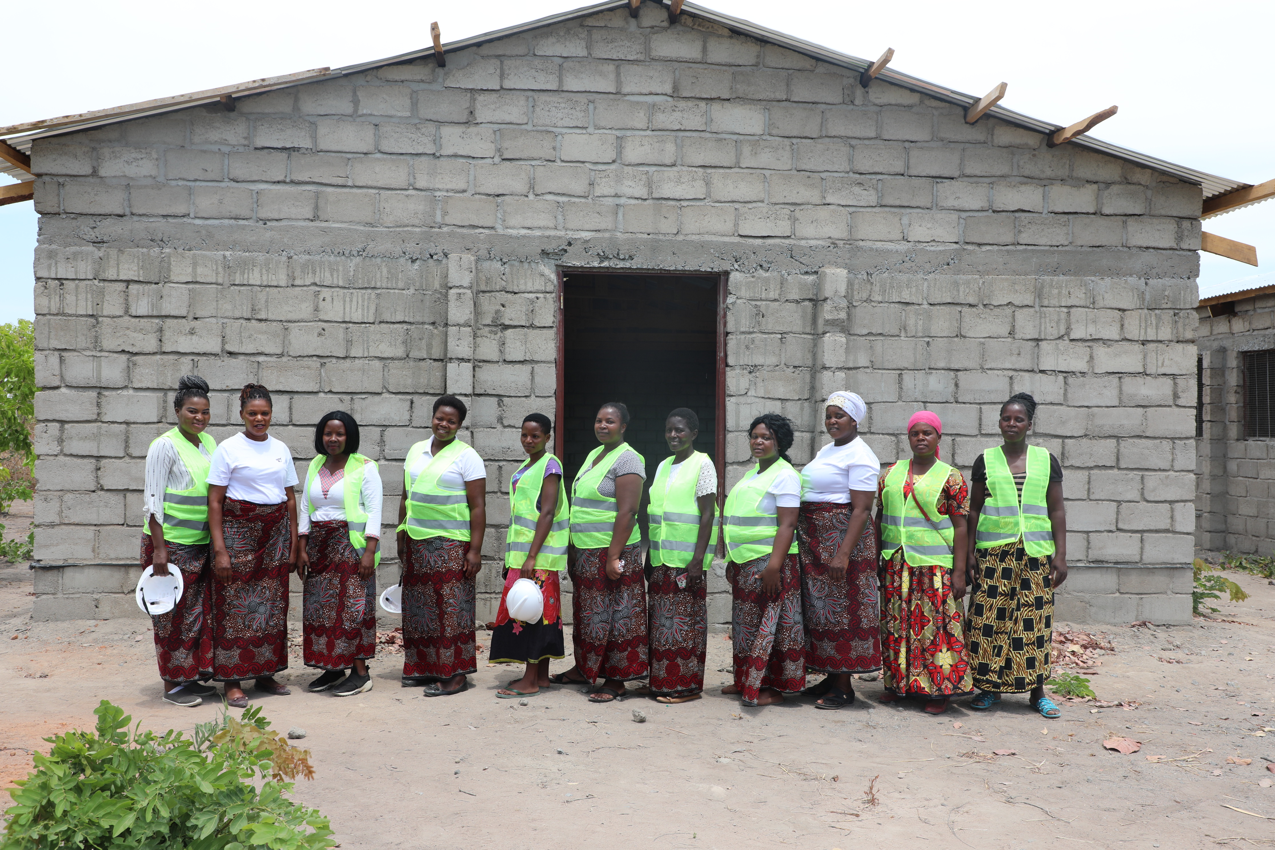 Amazing Grace Women Farmers stand in front of chicken kraal under construction 
