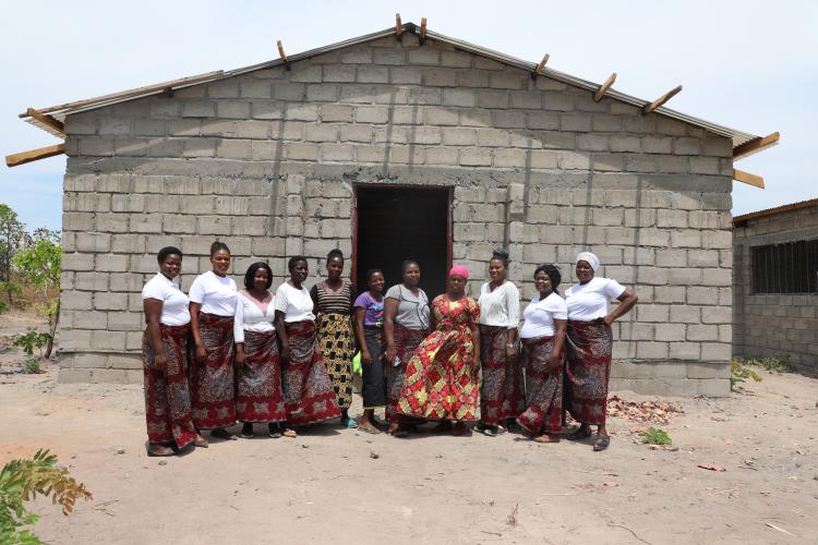 Amazing Grace Women Farmers stand in front of chicken kraal under construction 